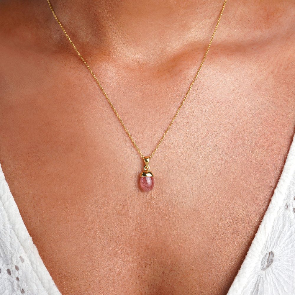 Trumlad Jordgubbskvarts kristall i guld att bära i halsband. Smycken med kristallen Jordgubbskvarts har en röd rosa färg.