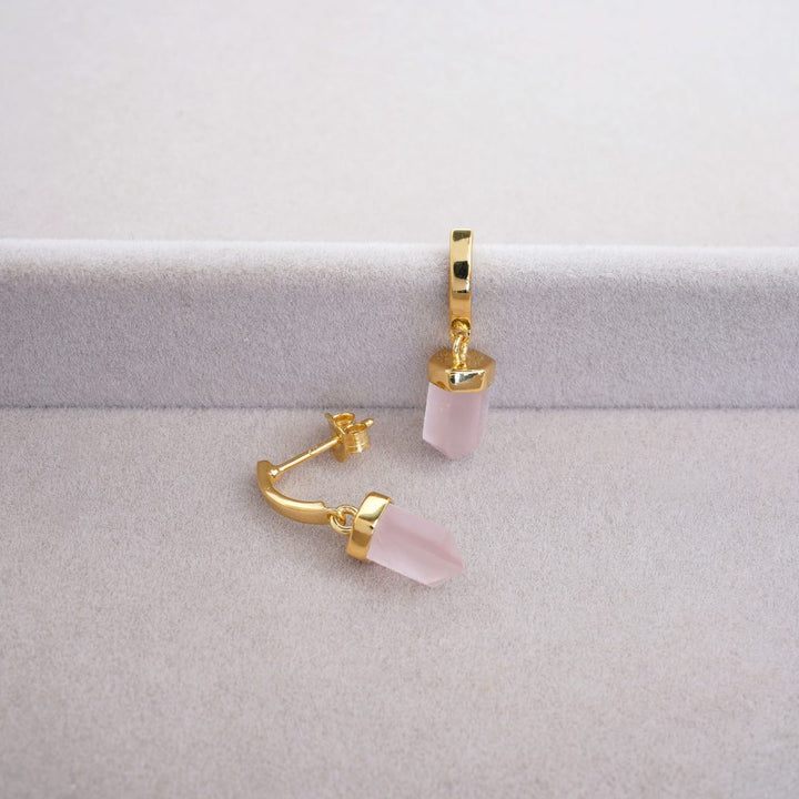 Örhängen med slipad Rosenkvarts kristall i spets form. Stilrena guldörhängen med rosa kristall Rosenkvarts som symboliserar kärlek.