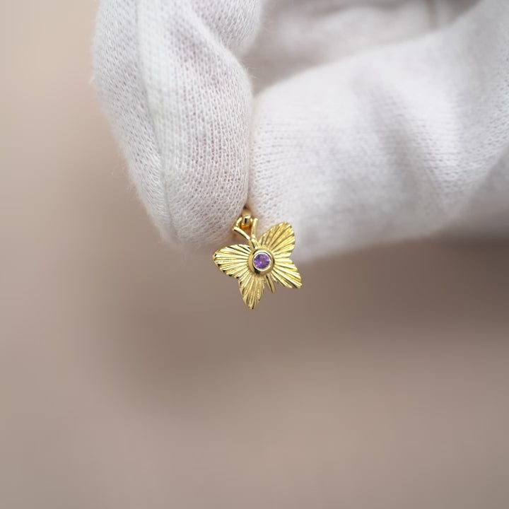Guldberlock med fjäril och lila ädelsten Ametist. Kristallsmycke i guld med fjäril och lila kristall Ametist.