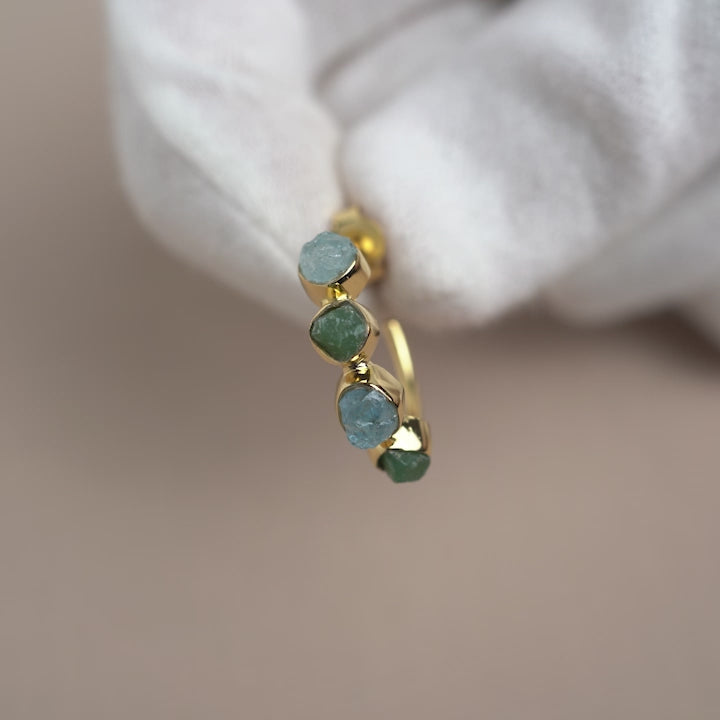 Råa kristallörhängen med Akvamarin och Aventurin i guld. Råa kristaller örhängen i guld med gröna och blåa stenar.