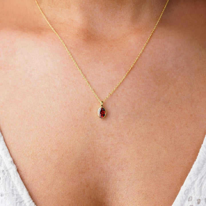Granat halsband i guld som är månadssten för januari. Smycke med röd kristall Granat som står för passion.