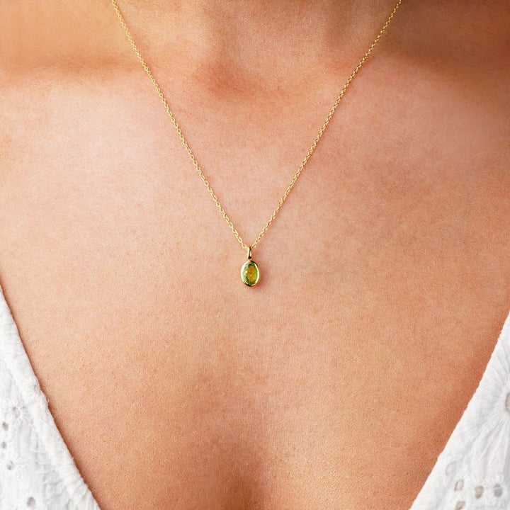 Halsband med grön Peridot kristall som är månadssten för augusti. Smycke med grön sten Peridot i guld att bära som halsband.