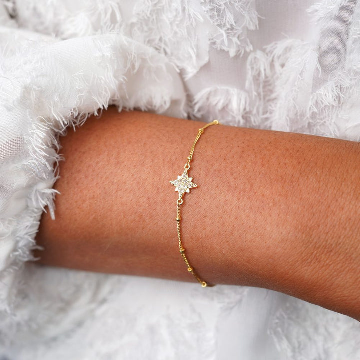 Guldarmband med stjärna av kristaller. Vackert armband i guld och med glittrande stjärna.