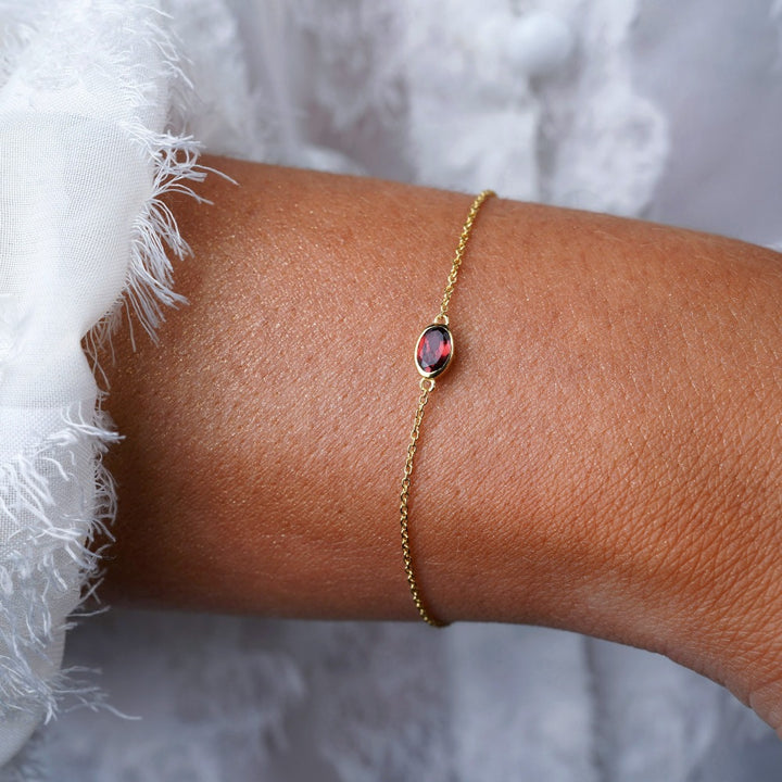 Guldarmband med röd kristall Granat. Armband med januari månadssten Granat i guld.