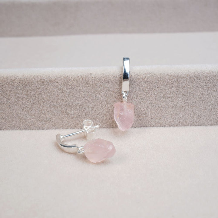 Stilrena örhängen i silver och med liten rosa rå kristall.  Rosenkvarts örhängen i silver och stilren design.